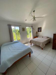 una camera con 2 letti e un ventilatore a soffitto di Casa los Titos a Manzanillo