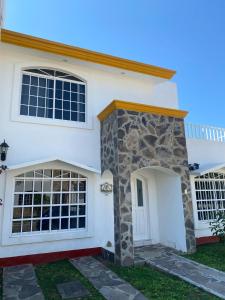 a white house with an archway and a door at Casa los Titos in Manzanillo