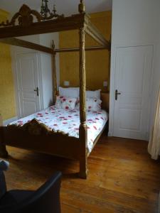 a bedroom with a canopy bed with a wooden floor at Gîte Chateau baie de somme 10 a 12 personnes in Mons-Boubert