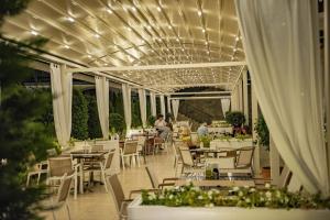 a restaurant with white tables and chairs and lights at Green Life Beach Resort Apartment in Sozopol