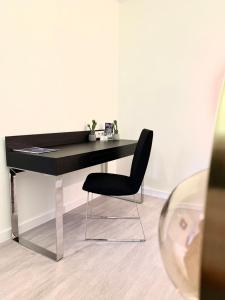 einen schwarzen Schreibtisch mit einem schwarzen Stuhl in einem Zimmer in der Unterkunft L'appart des Tanneurs in Metz