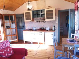a kitchen with white cabinets and a wooden floor at Domek na Skraju Wsi dostęp do jeziora UBLIK in Konopki Wielkie