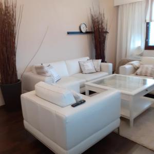 a living room with a white couch and a table at Lohja Lempola 2 room apartment in Lohja