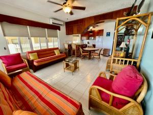 a living room with couches and a dining room at Belizean Reef Suites in San Pedro