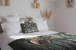 a bed with a book and a plate on it at LE MAS de PAUL in Saint-Julien-de-Cassagnas +32 photos
