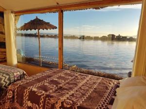 a bedroom with a window looking out at the water at Habitacion vista Amanecer, los Uros in Ocosuyo