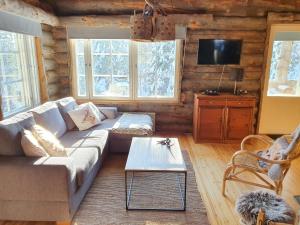 a living room with a couch and a table at Kelokuura Ruka in Ruka