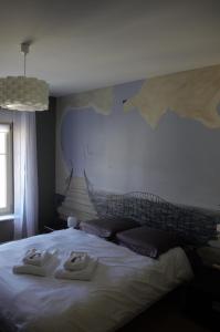una camera da letto con un letto e due asciugamani di La Maison de L Artiste - Chambres d'hôtes à Verdun - avec jacuzzi a Verdun-sur-Meuse