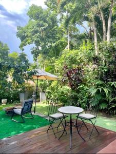 a table and two chairs and an umbrella on a deck at Entire private Beautiful 2 Bedroom plus Den House with gated front&back yard and Free parking 10min drive to the beach in Miami