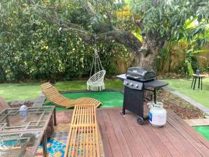 a patio with a grill and a table and chairs at Entire private Beautiful 2 Bedroom plus Den House with gated front&back yard and Free parking 10min drive to the beach in Miami