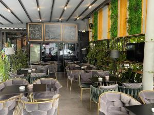 een restaurant met tafels, stoelen en planten bij VILA SANREMO in Tirana
