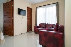 a living room with a couch and a tv at RedDoorz near ITDC Nusa Dua in Nusa Dua