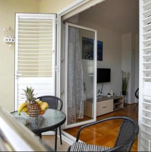 a dining room with a table with a pineapple on it at Apartman Ivešić in Makarska +10 photos