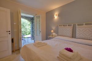 ein Schlafzimmer mit einem großen weißen Bett mit Handtüchern darauf in der Unterkunft I Giardini di Camogli - VILLA RUMANIN, garden&pool in Camogli