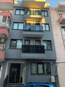 un edificio con balcones y un coche azul aparcado delante en NR1 HOTEL, en Canakkale