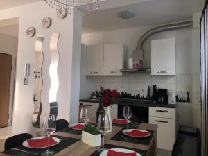 a kitchen with a table with red plates and wine glasses at Apartman Ivešić in Makarska