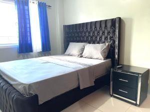 a bed with a black headboard in a bedroom at Residencial PALMA REAL in Santiago de los Caballeros