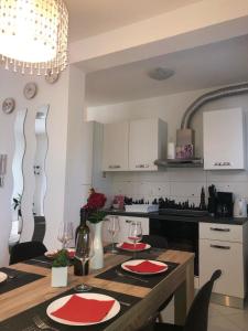 a kitchen with a table with red napkins on it at Apartman Ivešić in Makarska