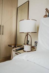 イスタンブールにあるServiced Luxurious 3+1 in Address Emaar Squareのベッド横のテーブルに座るランプ