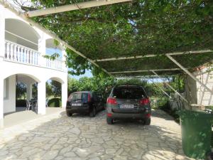 two cars parked in a parking lot next to a building at Apartman Vir Gogo br 5 in Vir