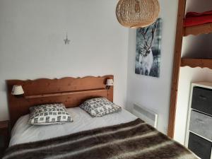 1 dormitorio con 1 cama con 2 almohadas en La Petite Foret Chamrousse 1700, en Chamrousse