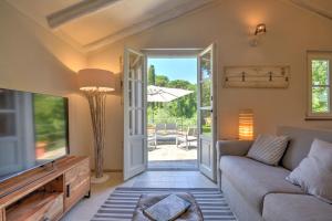 ein Wohnzimmer mit einem Sofa und einem TV in der Unterkunft I Giardini di Camogli - VILLA RUMANIN, garden&pool in Camogli