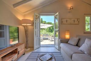a living room with a couch and a tv at I Giardini di Camogli - VILLA RUMANIN, garden&pool in Camogli
