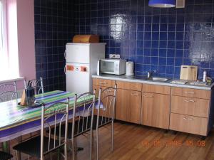 a kitchen with a refrigerator and a table and chairs at Gulbės Namai in Druskininkai