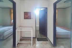 einen Spiegel in einem Zimmer mit 2 Betten und einem Tisch in der Unterkunft Mataram Cottage Syariah Mitra RedDoorz in Pasakon 1