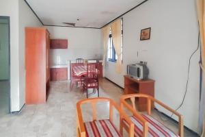 ein Zimmer mit Tisch und Stühlen und einem Fernseher in der Unterkunft Mataram Cottage Syariah Mitra RedDoorz in Pasakon 1