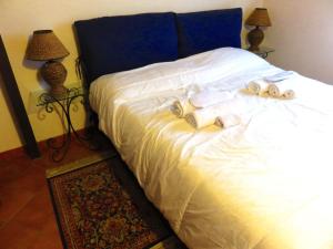 1 cama blanca con toallas y 2 lámparas en Kame house, en Castelbuono