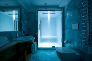 een badkamer met een douche, een toilet en een wastafel bij Hotel Cortina in Cortina dʼAmpezzo