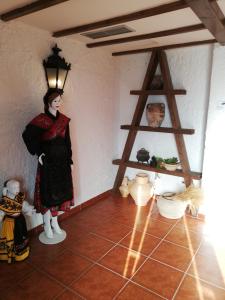 a woman standing in a room with a lamp at Hotel Rural El Vedal in Muelas del Pan