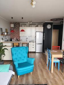 uma cozinha com uma cadeira azul e uma mesa em Przytulne i Komfortowe Mieszkanie Nad Morzem em Pogórze