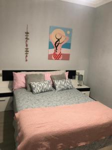 a bedroom with a bed with a pink comforter at Residencial Atlantico I in Costa Del Silencio +26 photos
