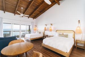 a bedroom with a bed and a couch and a table at The Beach House Boutique Hotel in West End