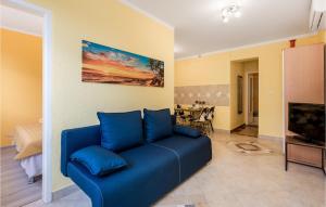 ein blaues Sofa im Wohnzimmer mit einem TV in der Unterkunft 1 Bedroom Stunning Apartment In Pobri in Volosko