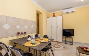 ein Esszimmer mit einem Tisch mit Stühlen und einem TV in der Unterkunft 1 Bedroom Stunning Apartment In Pobri in Volosko