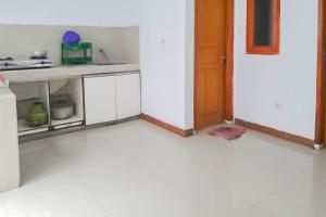 eine Küche mit weißem Boden und einer Tür in der Unterkunft Angel Guest House Lembang RedPartner in Lembang