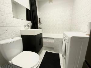 ein weißes Bad mit einem WC und einem Waschbecken in der Unterkunft Best View Apartment in Toruń