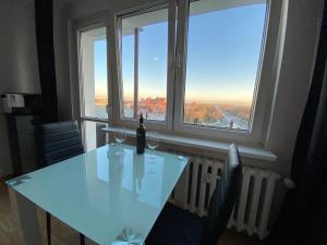 einen weißen Tisch mit zwei Weingläsern und einem Fenster in der Unterkunft Best View Apartment in Toruń