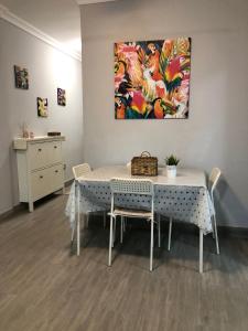 a dining room table with chairs and a painting on the wall at Residencial Atlantico I in Costa Del Silencio