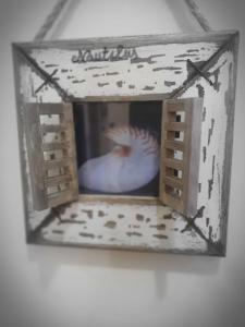 une photo d'un oiseau dans une boîte sur un mur dans l'établissement La Finestra sul Mare, à Ischia
