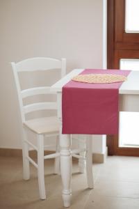 a white table and a chair with a purple cloth on it at B&B Pozzorosso in Vasto