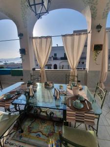 una sala da pranzo con tavolo in vetro e sedie di La Finestra sul Mare a Ischia