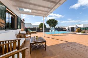 un patio con una pérgola blanca y una mesa en Villa Lele, en Playa Blanca