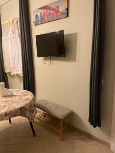 a room with a tv on a wall with a chair at Casa del sasso in Bergeggi