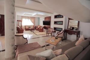 a living room with a couch and a table at Magnifique Villa Avec Piscine, Pour Vos Vacances ! in Monastir