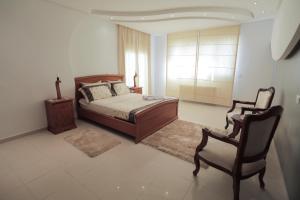 a bedroom with a bed and a chair at Magnifique Villa Avec Piscine, Pour Vos Vacances ! in Monastir +41 photos