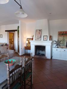 sala de estar con mesa y chimenea en Casa rural La Vega, en Cazalla de la Sierra